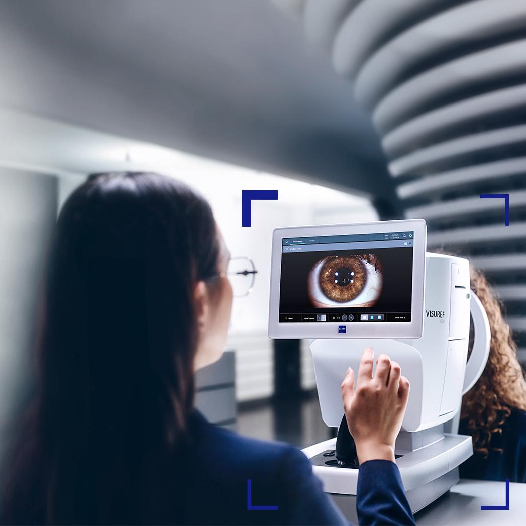 En kvindelig optiker ser på skærmen på ZEISS VISUREF 600, der viser et billede af et øje.