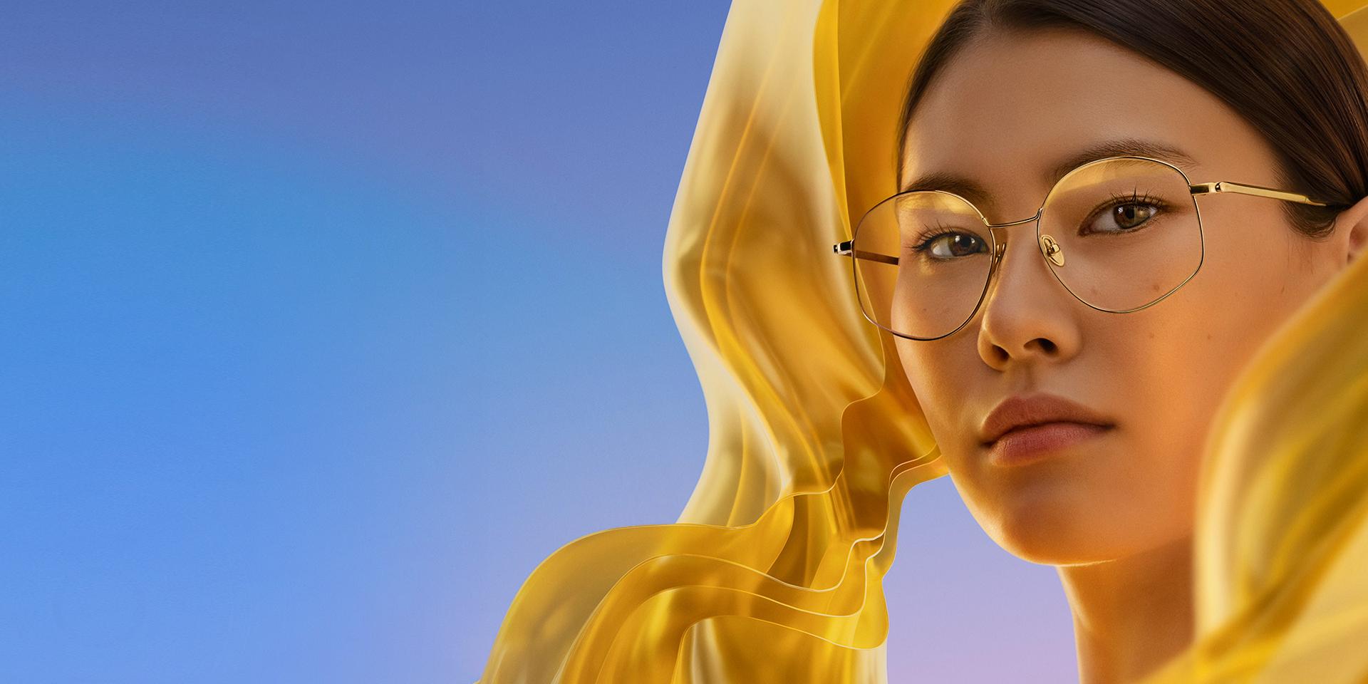 En kvinde bærer klarer briller med ZEISS DuraVision Gold UV, der giver en subtil men distinkt gylden refleksion i brilleglassene.