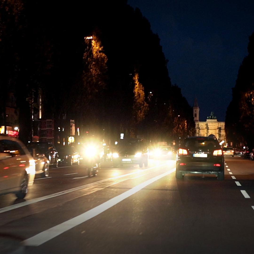 Modkørende biler der blænder om natten, og genskær fra våde vejbaner 
