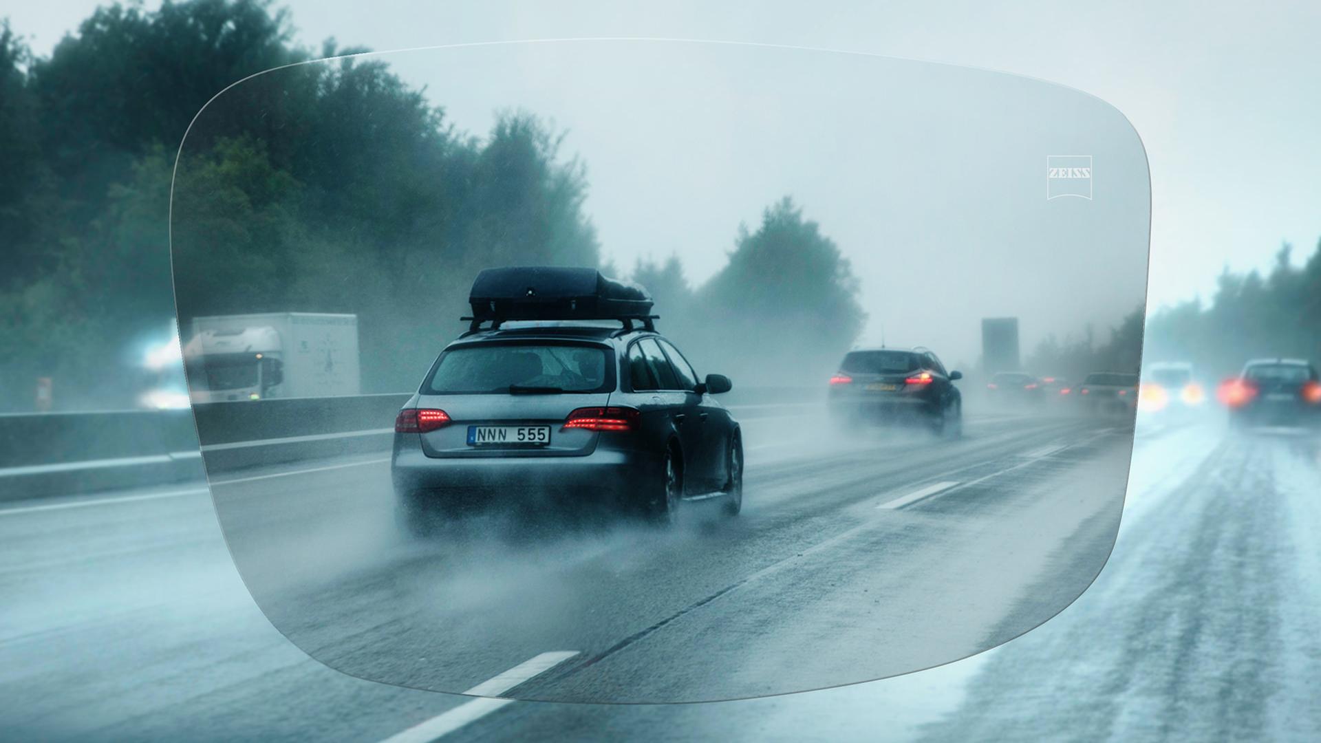 Visning af en motorvej set gennem ZEISS DriveSafe Single Vision brilleglas i regnvejr 