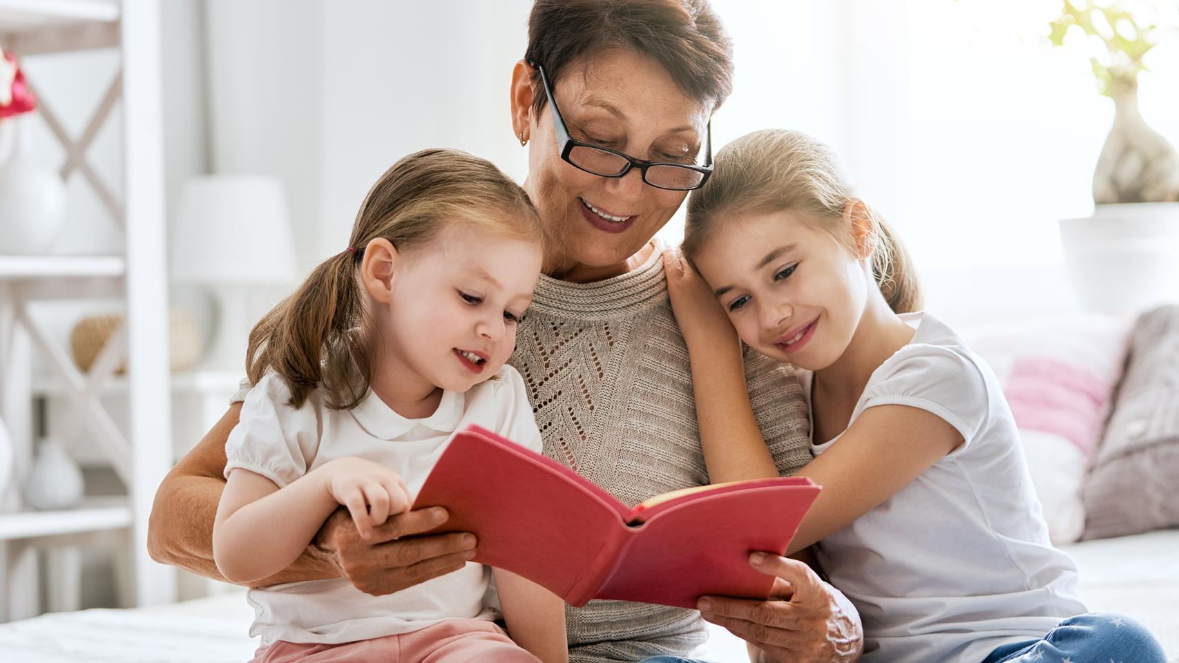 Bedstemor der læser højt for børnebørnene fra en bog