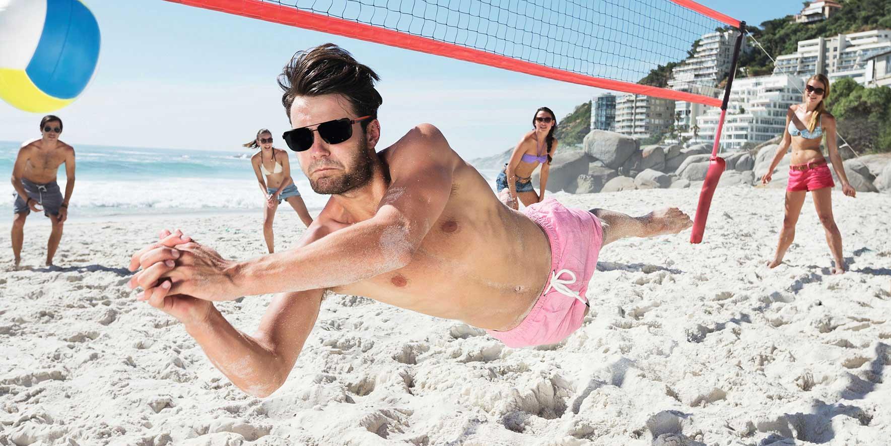 Folk på stranden spiller beachvolley