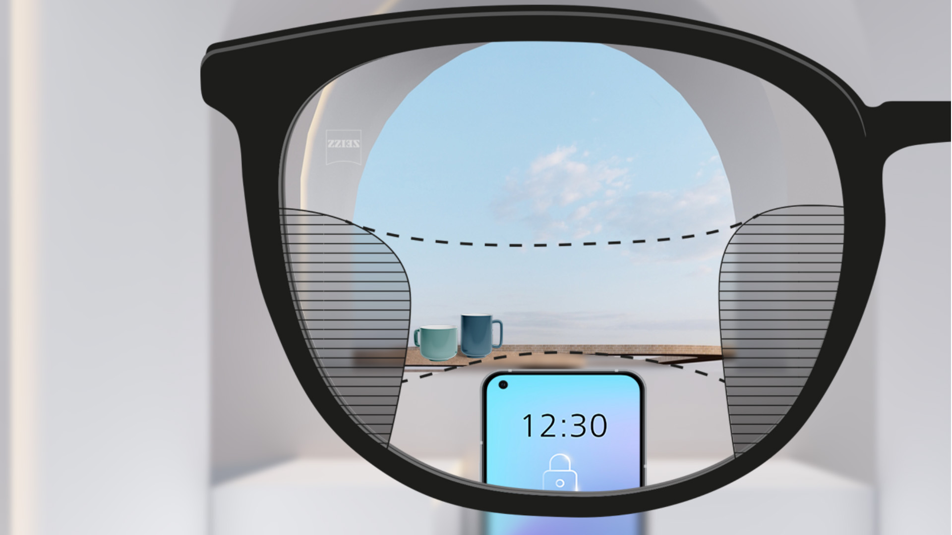 Et udsnit af et billede med ZEISS Progressive SmartLife brilleglas med en smartphone og kopper i baggrunden og brilleglasset helt klart med smalle slørede pletter til venstre og højre.
