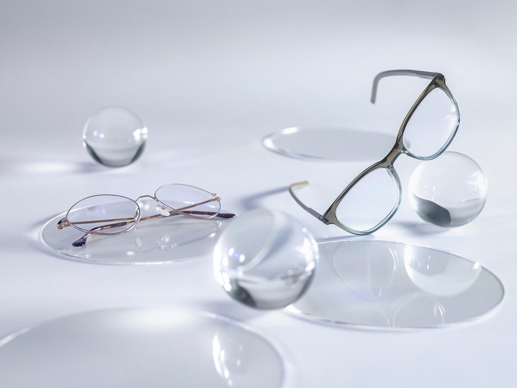 Briller med ZEISS brilleglas, forsynet med DuraVision® Silver coating, og som ses uden reflekser i sammenligning med de omkringværende glas-sfærer.