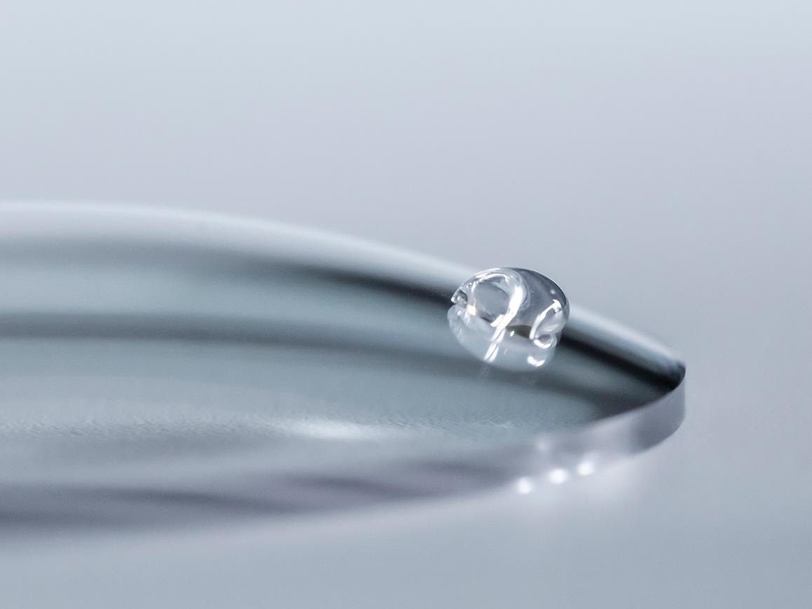 En vanddråbe glider af et ZEISS brilleglas med an coating, der er let at rengøre.