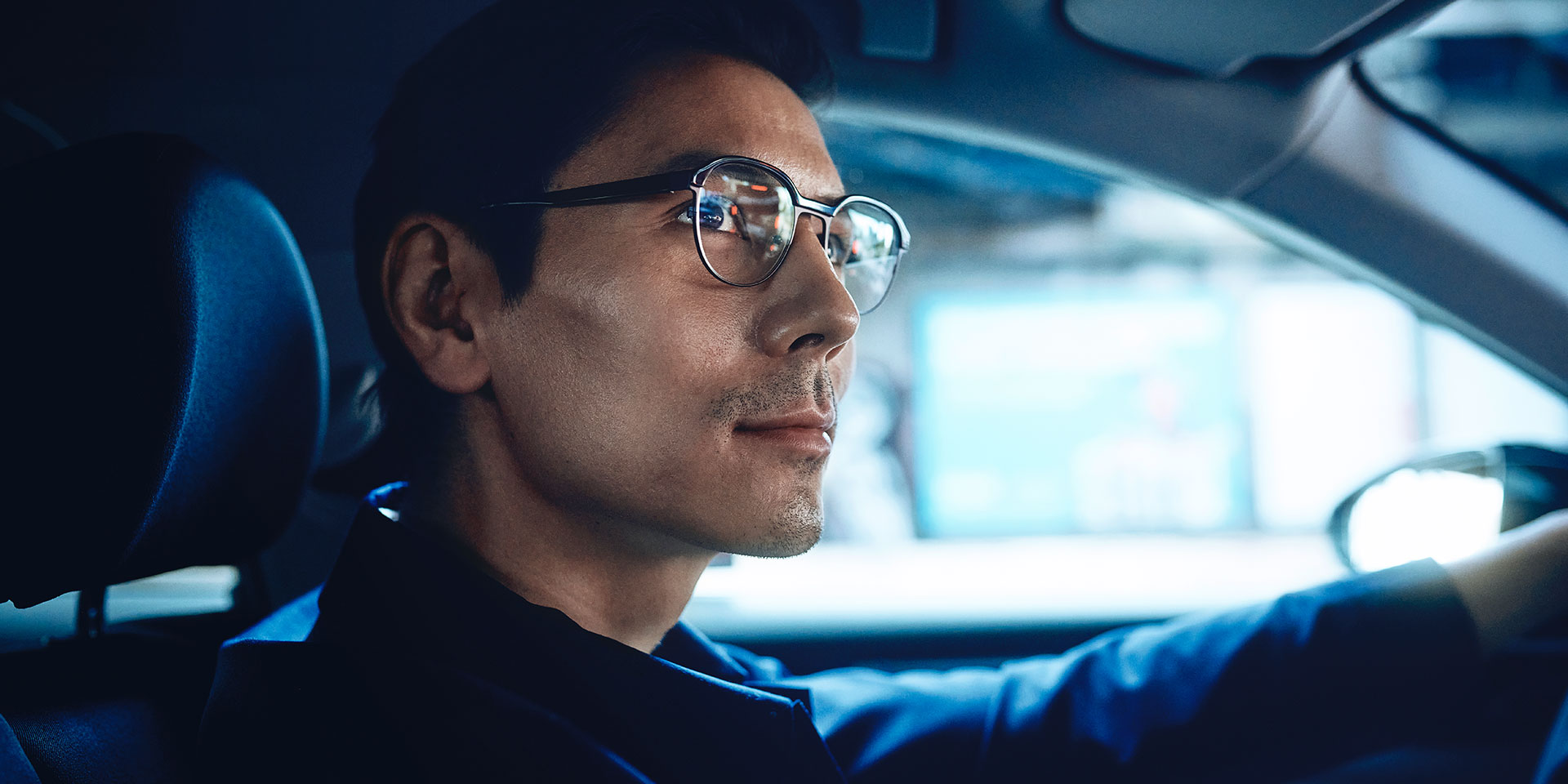 Mand der kører i en bil og ser selvsikker ud med et lille smil på vejen. Han har ZEISS DriveSafe briller med enkeltstyrke på.