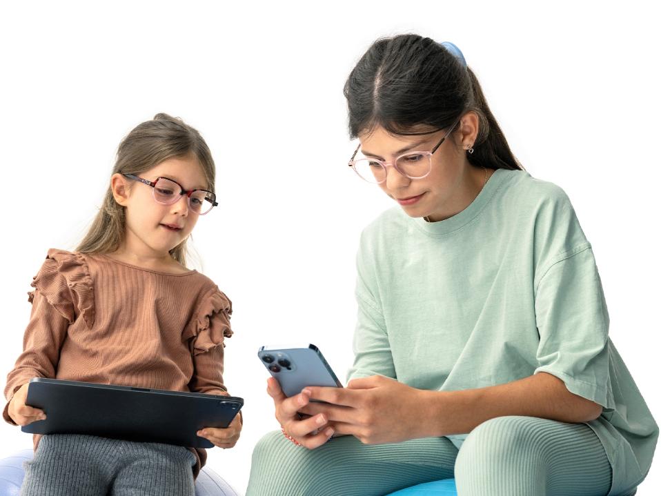 To piger der ser på digitale enheder i den foreslåede afstand på mere end 20 cm.