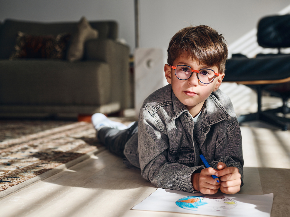 En lille dreng med ZEISS MyoCare brilleglas ser lige ind i kameraet.