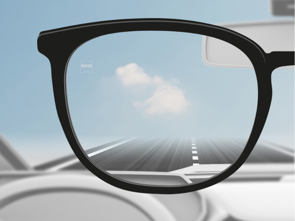 Skematisk illustration af et punkt set gennem et DriveSafe enkeltstyrkebrilleglas, der viser et klart syn over vejen. . 
