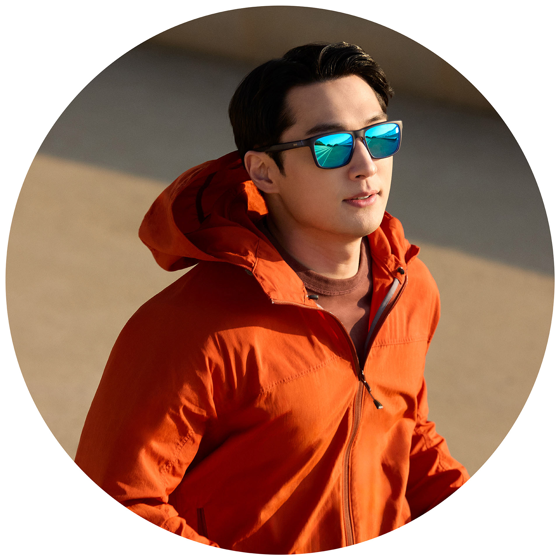 En jogger i en orange jakke, og som bærer ZEISS solbriller med styrke med en blå spejloverfladebehandling.