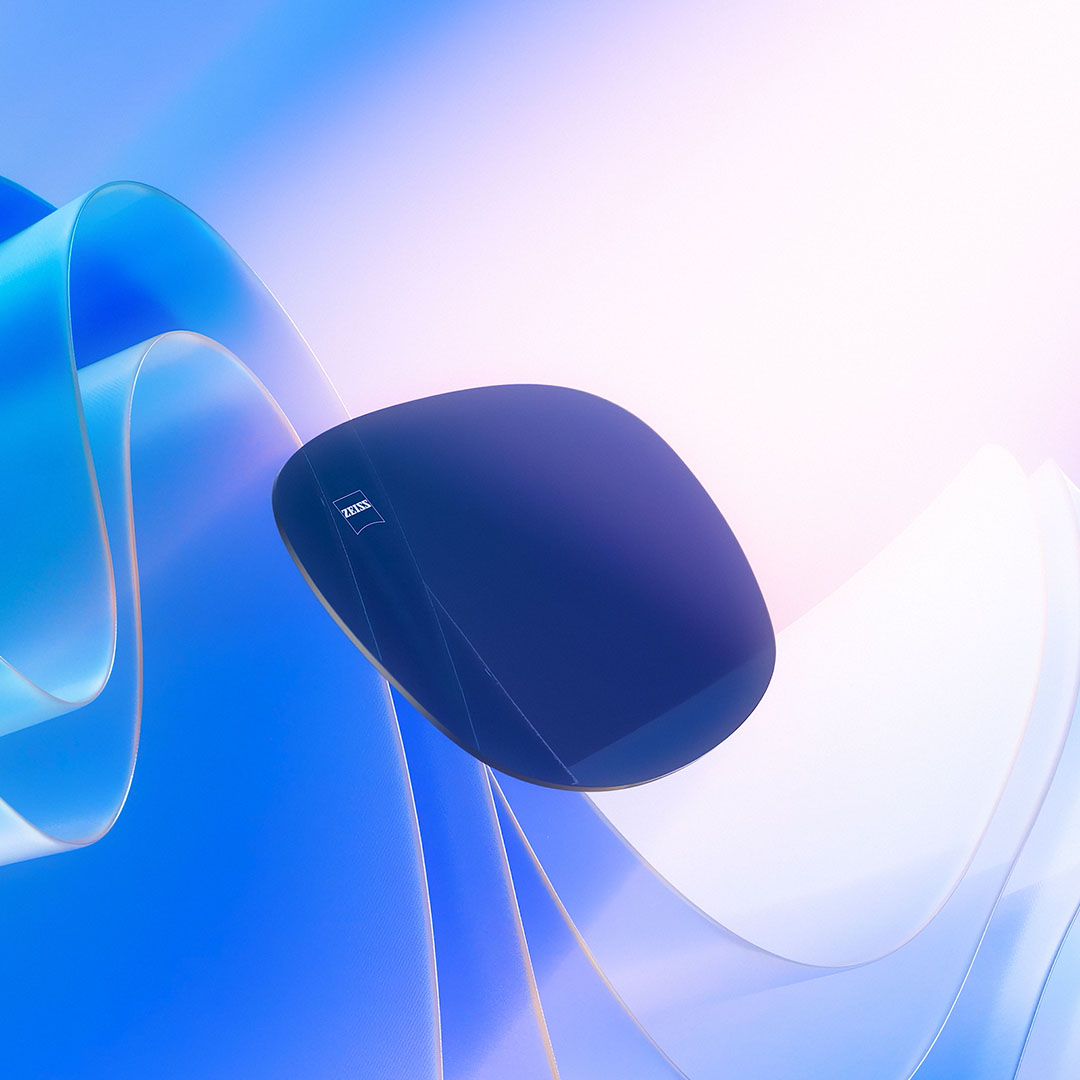 Der vises en CGI-illustration af et farvet brilleglas, der svæver hen imod sollys til visning af dets evne til at blokere UV-stråler