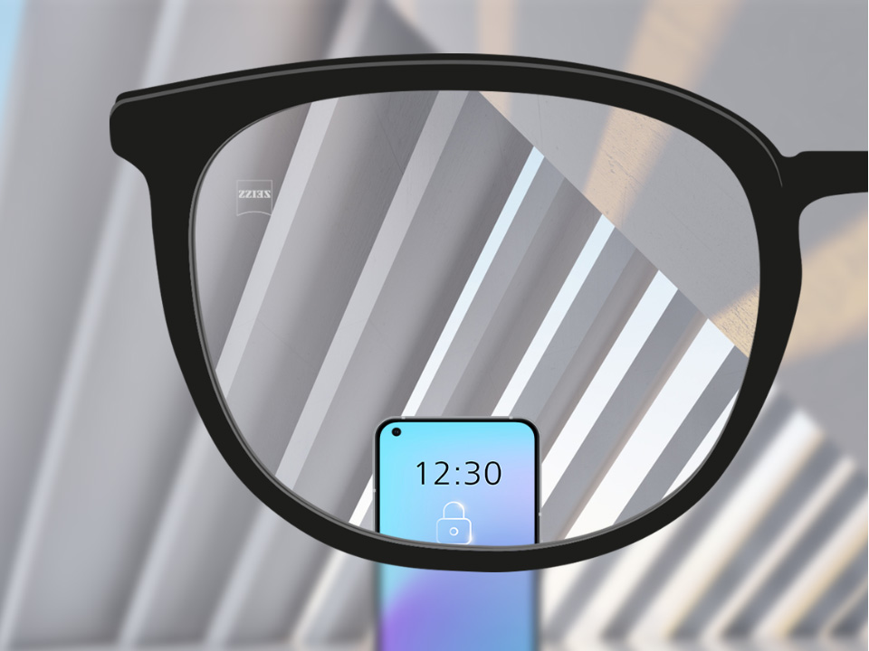 Et udsnit af et billede med ZEISS Single Vision SmartLife brilleglas med en smartphone og brilleglasset helt klart. 