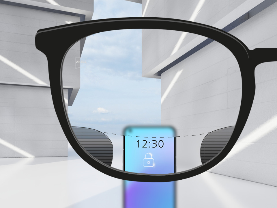 Et udsnit med ZEISS Digital SmartLife brilleglas med en smartphone og brilleglasset helt klart i øverste og nederste område af glasset og små slørede pletter til venstre og højre. 