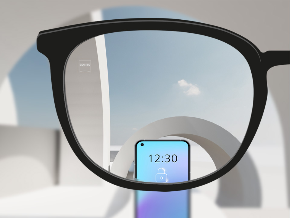 Et udsnit af et billede med ZEISS Single Vision SmartLife brilleglas med en smartphone og brilleglasset helt klart.