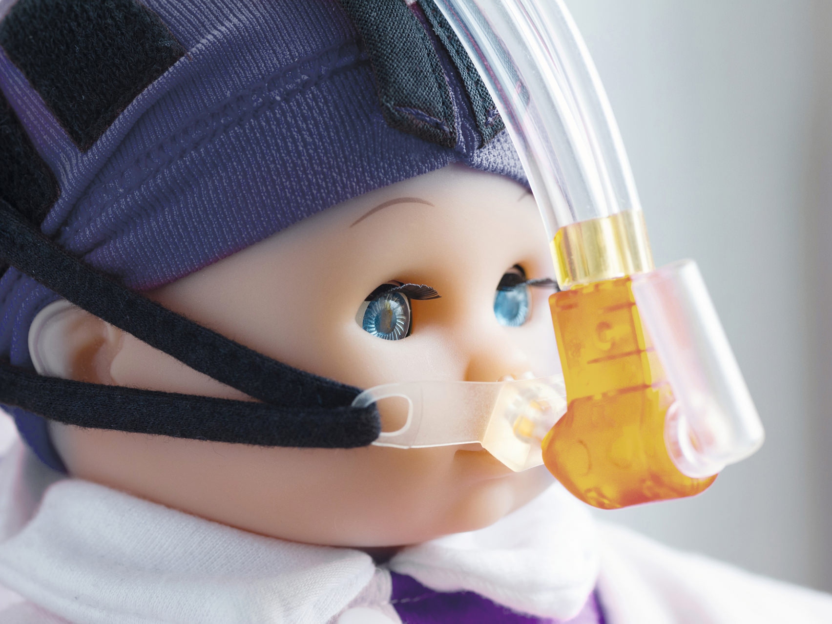 Nærbillede af en dukkes ansigt med en åndedrætsmaske.