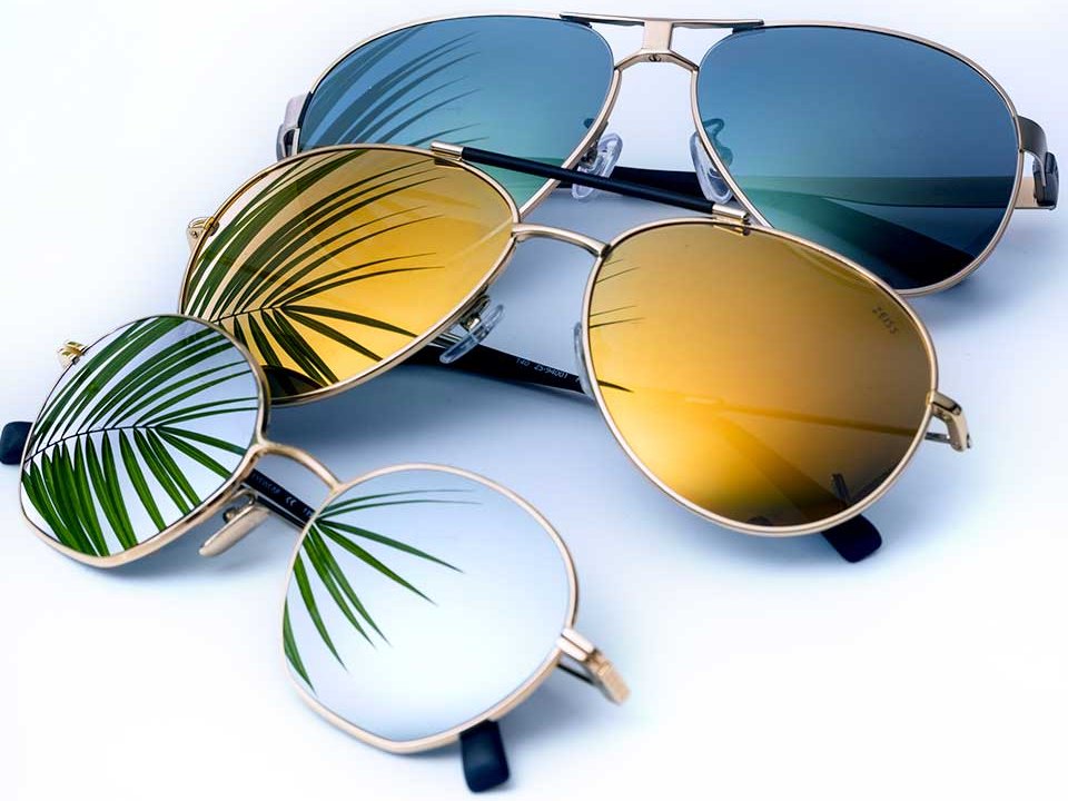 Fotografi af tre solbrilleglas med Mirror Lens Coatings i forskellige farver (klare, gule og blå) 