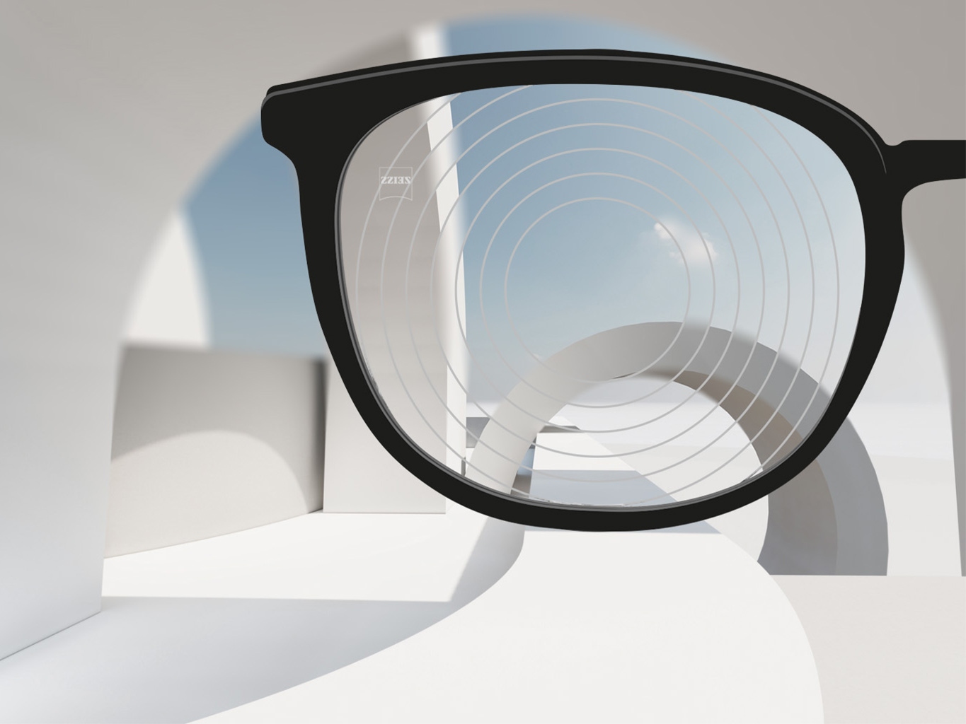 Et nærbillede af brilleglas til myopibehandling fra ZEISS, med et sort brillestel og koncentriske ringe på glassets overflade.