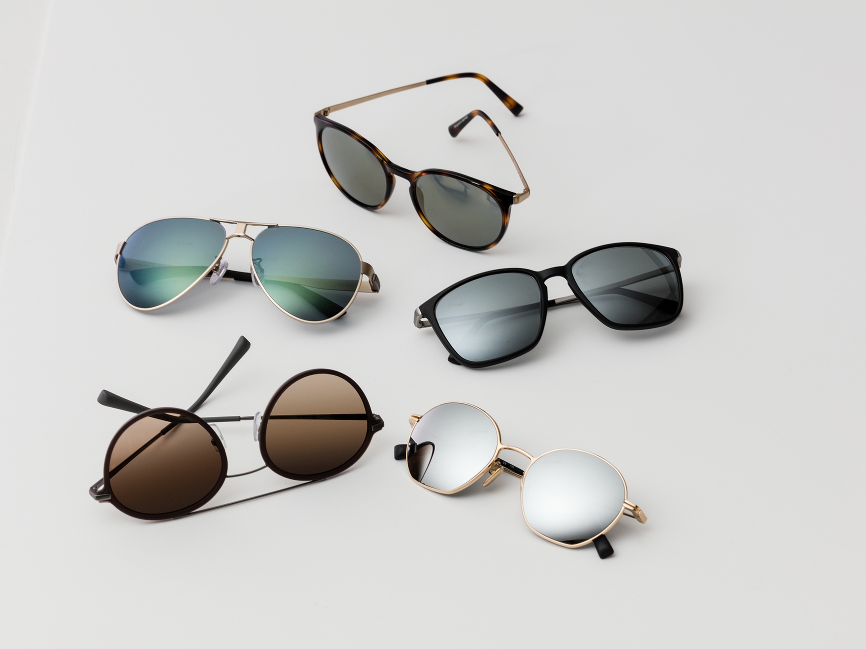 Fem par solbriller med de klassiske solbeskyttelsesfarver til medium og til kraftigt lys.