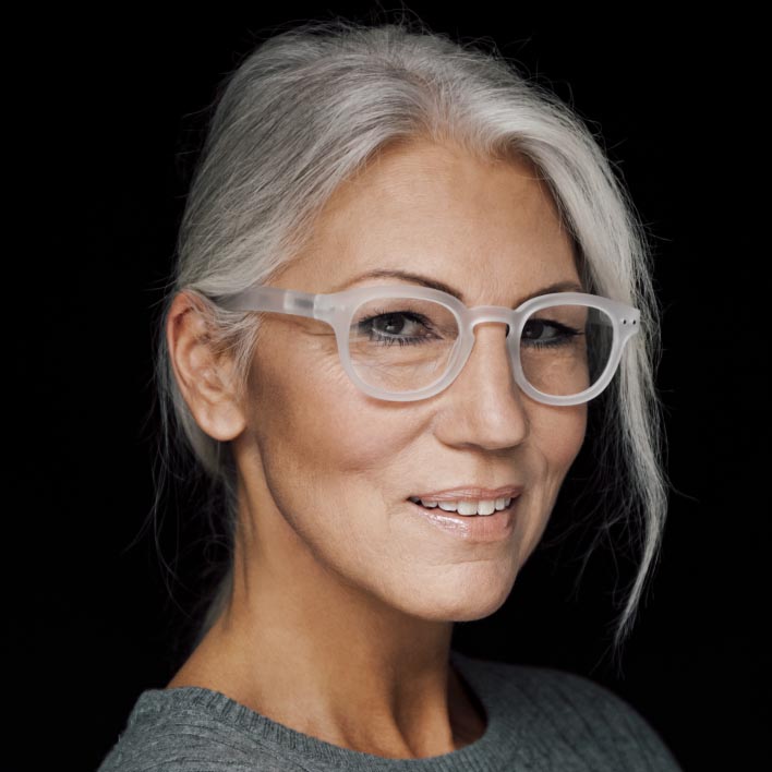 Kvinde med gråt hår med briller med hvidt stel og ZEISS Progressive SmartLife brilleglas. Geometrisk ansigtsscanning der viser målinger af anatomi- og stelmålinger.